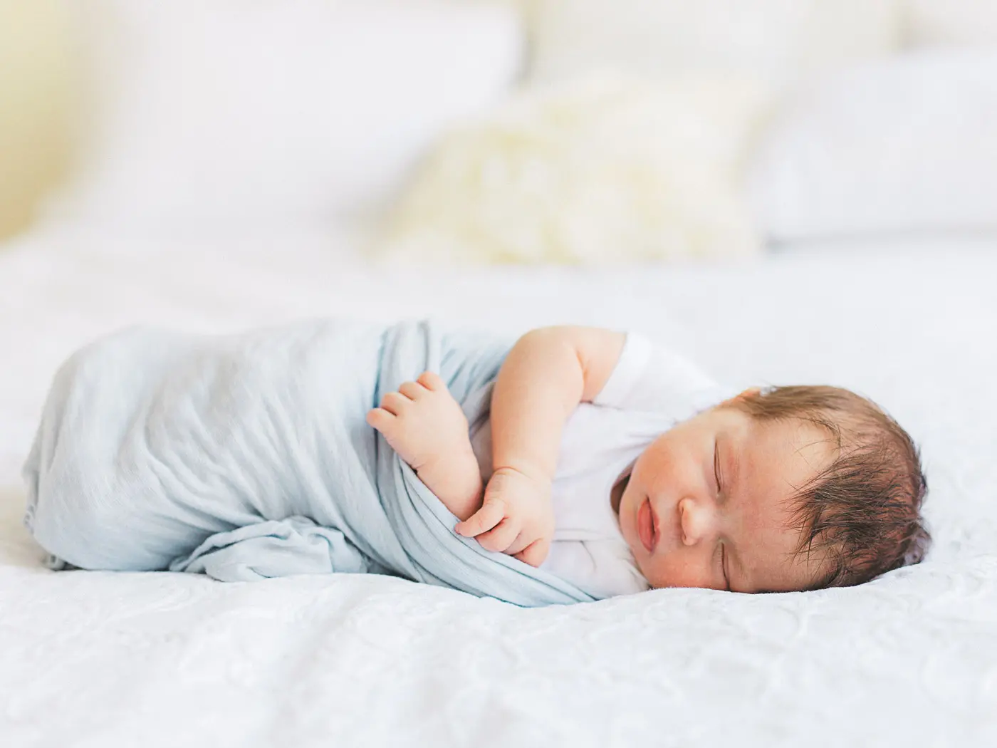 Portrait of newborn baby boy in blue swaddle