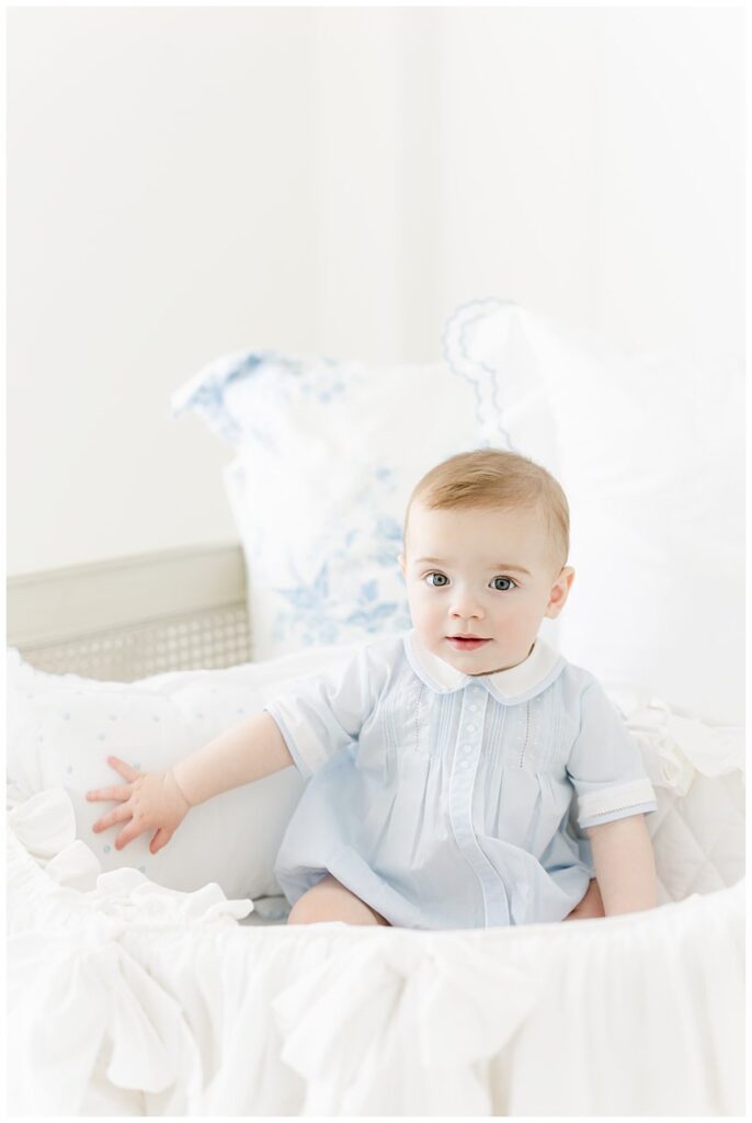 6month Baby boy wearing a feltman brothers outfit in a ruffle basket in a Savannah GA Newborn Photographer Studio