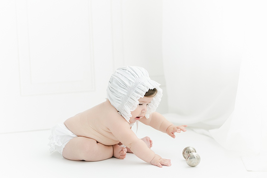 6 month baby girl wearing a bonnet and ruffle bloomers in a Savannah Baby Photographer Studio